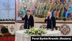 Chinese President Xi Jinping (left) and Russian President Vladimir Putin attend a reception in Moscow on March 21.