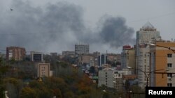 Smoke rises above buildings after a warehouse was hit by Russian shelling in Donetsk, Russian-controlled Ukraine, on October 21.