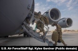 U.S. airmen in Qatar board a transport aircraft involved in withdrawing American-led forces from Afghanistan on April 27.