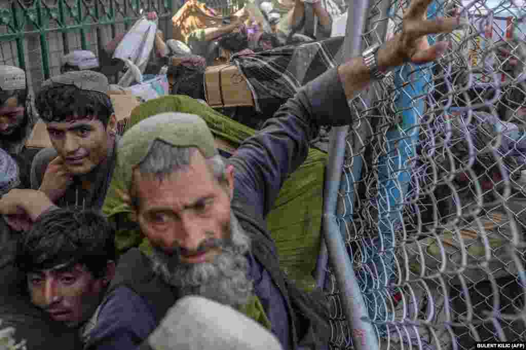 Afgani se grăbesc să treacă prin punctul de frontieră Spin Boldak, aflat la granița dintre Afganistan și Pakistan. 