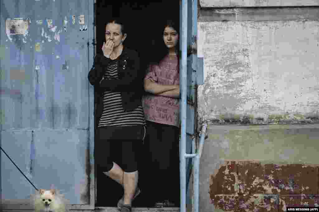 Women stand at the door of their apartment building in Lysychansk.&nbsp;