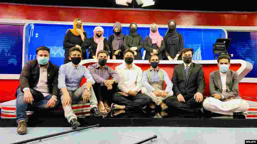 Afghan men at Tolo TV wear face masks to show solidarity with their female colleagues, who were ordered to wear veils at the studio in Kabul.