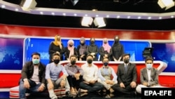 کارکنان مرد تلویزیون «طلوع» افغانستان در همبستگی با همکاران زن خود که مجبور به رعایت حجاب شده‌اند، ماسک به صورت زده‌اند