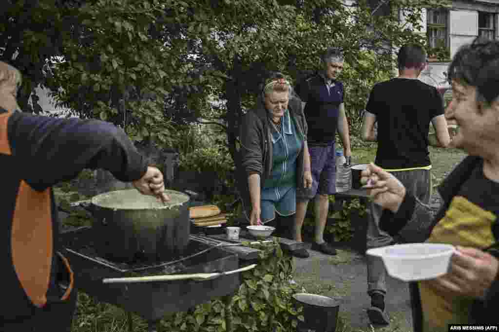 Helyi lakosok az utcán főznek, miután elcsendesedtek a bombázások Liszicsanszkban. Sem Liszicsanszkban, sem Szeverodonyeckben nincs víz, áram és gáz. A városokból kivezető utakat súlyosan megrongálták az orosz csapatok