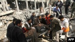 Palestinian men and medics remove bodies from the site of the destroyed former office of Palestinian President Mahmud Abbas following an Israeli air strike in Gaza City.