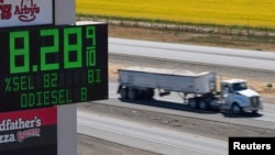 A truck in California drives a past sign showing fuel prices. (file photo)
