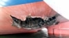 This undated handout photograph released by South Korea's Foreign Ministry shows a damaged part of the cargo ship HMM Namu docked at a port in Dubai.