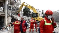 Echipe de intervenție lucrează la locul unei lovituri asupra unei clădiri rezidențiale din Teheran. 