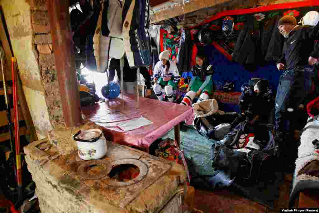 Young hockey players, including members of Kyrgyzstan&#39;s first female team, prepare in a dressing room before a training session in the village of Otradnoye. (Reuters/Vladimir Pirogov)