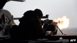 Боєць добровольчого батальйону «Правий сектор» відстрілюється від нападу сепаратистів на село Піски неподалік Донецького аеропорту, фото 3 січня 2015 року