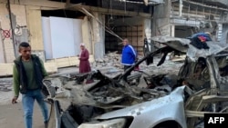 Njerëzit duke e shikuar veturën në të cilën tre djem të liderit të Hamasit u vranë nga një sulm izraelit në Rripin e Gazës, 10 prill 2024.