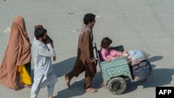 یک فامیل افغان در نزدیک گذرگاه تورخم که می‌خواهد ازپاکستان به افغانستان برگردد.