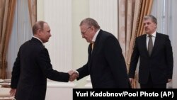 Russian President Vladimir Putin (left) meets with opposition candidates who ran against him in the presidential election, shaking hands with Vladimir Zhirinovsky at the Kremlin in March 2018.