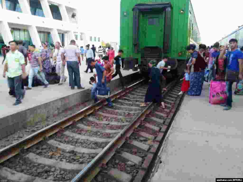 Adamlar otlynyň arkasyndan geçip barýarlar.