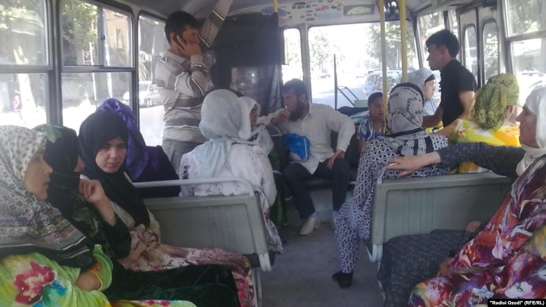 Tajik women wear hijab while riding in a bus. (file photo)