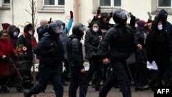 Сотрудники правоохранительных органов бегут блокировать дорогу, поскольку белорусские пенсионеры присутствуют на митинге протеста против насилия со стороны полиции в Минске, 30 ноября 2020 г.