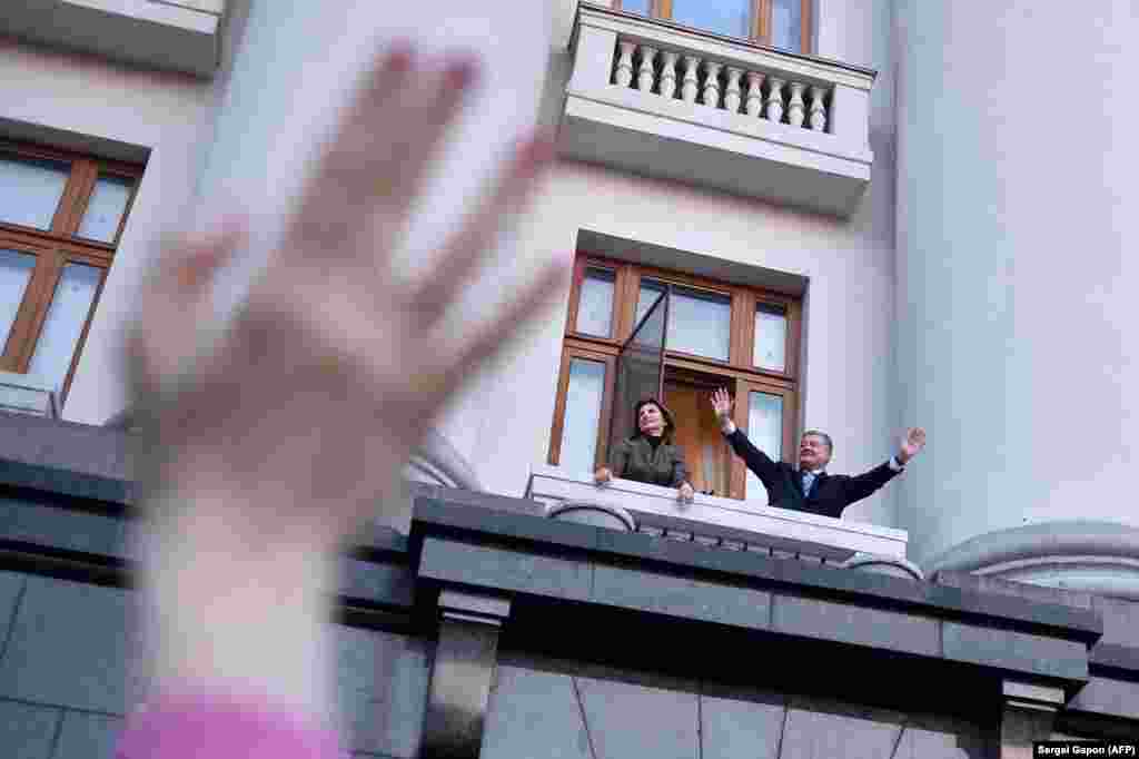 Outgoing Ukrainian President Petro Poroshenko and his wife, Maryna, greet supporters from the balcony of his office during a &quot;thank-you&quot; rally in Kyiv on April 22. Poroshenko was defeated in a landslide by comedian Volodymyr Zelenskiy in a runoff on April 21. (AFP/Sergei Gapon)​
