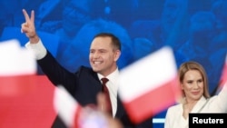 Candidatul naționalist, Karol Nawrocki, și soția sa, reacționând la aflarea rezultatelor exit poll în urma primului tur de scrutin al alegerilor prezidențiale poloneze din 18 mai, 2025