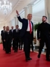Президент США Трамп веде Білим домом президента України Зеленського, за ними йдуть очільники Британії, Франції, Німеччини, Італії, Фінляндії, а також генесек НАТО і президентка Єврокомісії. Вашингтон, 18 серпня 2025 року