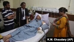 Pakistani TV anchorman Asad Kharal talks to visitors at a hospital in Lahore after he was stabbed by masked men near his residence on June 6.