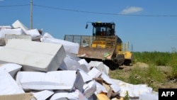 A bulldozer crushing boxes of cheese outside the Russian southern city of Belgorod on August 6, 2015.