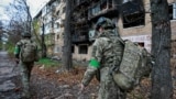 Ukrainian servicemen walk near an apartment building damaged by a Russian military strike in the frontline city of Kostyantynivka, in the Donetsk region on November 1.