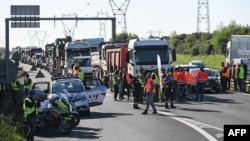 Франция. 7-апрель, 2026-жыл. Жумушчулар Бугнедеги айланма жолду тосуп, күйүүчү майдын кымбаттаганына нааразылык билдиришүүдө.