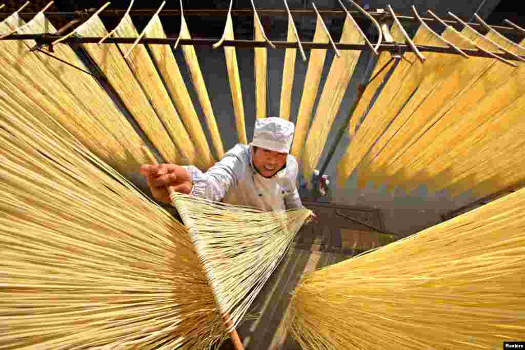 A villager hangs handmade noodles up to dry in Linyi, Shandong Province, China. (Reuters/Stringer)