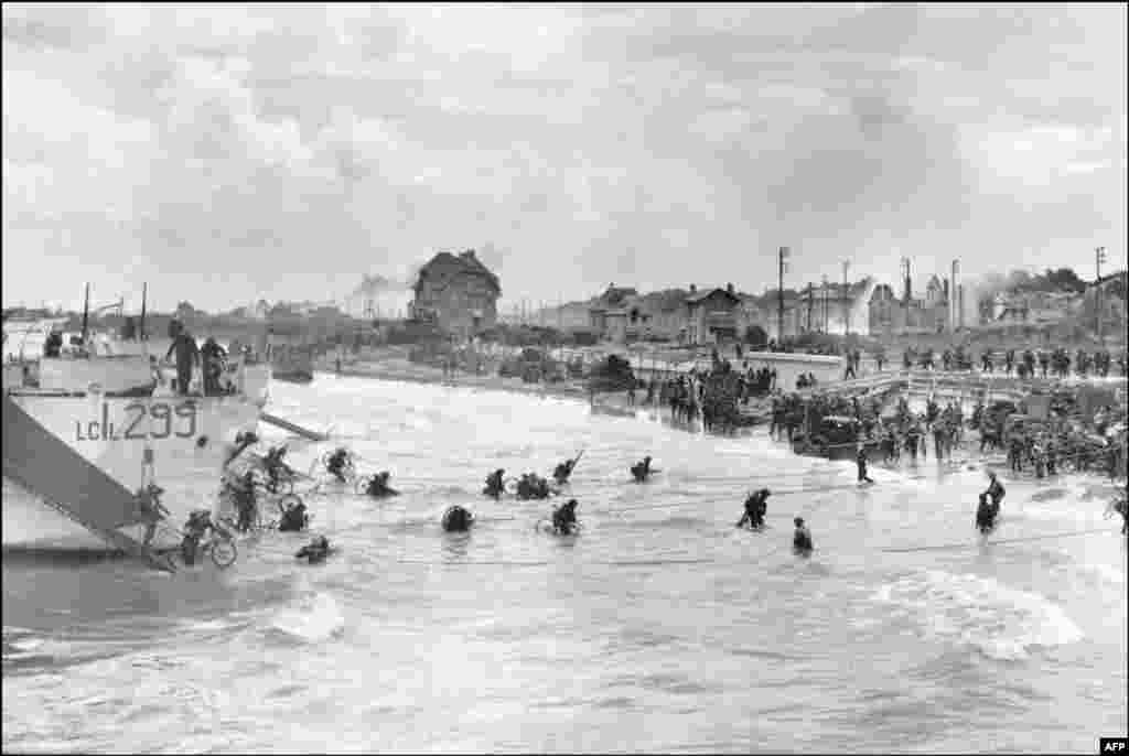 Kanadski vojnici iz 9. brigade iskrcavaju se 6. juna 1944. sa svojim biciklima na plaži Juno u Bernieres-sur-Mer-u, dok savezničke snage napadaju plaže u Normandiji. &nbsp;