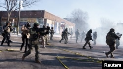 Minneapolisdə federal agentlər etirazçılara tərəf qaçır və gözyaşardıcı qaz atırlar.