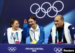 София Самоделкина, бапкері Рафаэль Арутюнян (оң жақта) және мәнерлеп сырғанаудан Қазақстан құрамасының бас бапкері Әсем Қасанова (сол жақта). Милан, Италия, 17 ақпан, 2026 жыл.