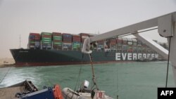 На снимке, опубликованном Управлением Суэцкого канала 25 марта 2021 года, изображен тайваньский MV Ever Given (Evergreen), судно застрявшее боком и препятствующее движению через водный путь Суэцкого канала в Египте.