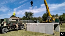 Rumunski vojni inženjeri postavljaju betonska skloništa u selu Plauru na granici rijeke Dunav između Rumunije i Ukrajine 12. septembra 2023.
