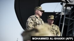 چند سرباز آمریکایی بر پهنه یکی از کشتی‌های جنگی این کشور که جزو ناوگان دریایی آمریکا در نزدیکی بحرین است