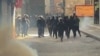 This grab taken on January 6, 2026, from UGC images posted on social media the same day shows Iranian security forces using tear gas to disperse protesters at the Tehran bazaar.
