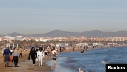 Spania a înregistrat cea mai caldă lună ianuarie de când face înregistrări meteorologice. Foto: Oamenii se plimbă de-a lungul țărmului mării pe plaja Malvarrosa din Valencia, Spania ianuarie 25, 2024