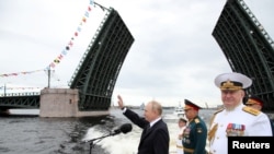 Președintele rus Vladimir Putin și șeful marinei ruse, amiralul Nikolai Yevmenov, la o paradă care marchează Ziua Marinei la Sankt Petersburg, Rusia, 31 iulie 2022.