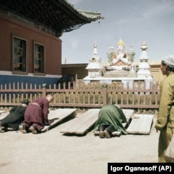 Štovatelji u samostanu Gandan u Ulan Batoru, 1962. Samo su se stariji budisti smjeli moliti u samostanu u to vrijeme, dok je mlađima bilo dopušteno da budu "slučajni promatrači".