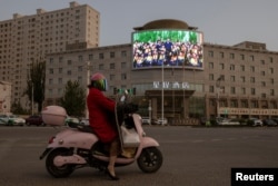 A screen shows a picture of Chinese President Xi Jinping at a traffic junction in Hotan, China.