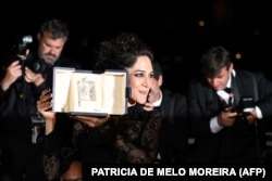 Iranian actress Zar Amir-Ebrahimi shows off her Best Actress award at Cannes on May 28.