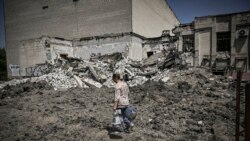 O femeie trece prin fața unei clădiri distruse de o bombă din orașul Lîsîceansk, diniregiunea estică a Ucrainei Donbas - 30 mai 2022 (Foto: AFP)