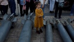 O fetiță între ceea ce a rămas din rachetele rusești care au atacat Kievul - 29 mai 2022 (REUTERS/Edgar Su)