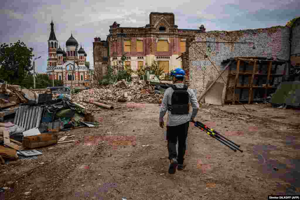 Emmanuel Durand, a French engineer, reviews the grounds of a historic fire station near Kharkiv&#39;s Church of the Three Saints, which was damaged by Russian bombardment. Durand spent two days mapping the &quot;amazing&quot; site and gaining the trust of the local fire department. The officials were so impressed with his completed 3D rendering that they gave him a private tour of a local museum. Volunteering for this activity &quot;brings a lot of joy,&quot; he told AFP, and having a &quot;very understanding wife&quot; also helps.