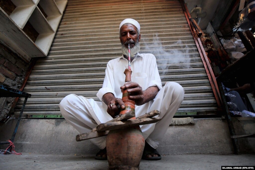 Një burrë duke tymosur duhan në Peshavar, Pakistan, më 30 maj.