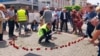 Okupljeni na centralnom trgu u Prijedoru u znak sjećanja na ubijene civile ostavljaju ruže s imenom ubijene osobe, 31. maj 2022.