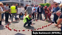 Okupljeni na centralnom trgu u Prijedoru u znak sjećanja na ubijene civile ostavljaju ruže s imenom ubijene osobe, 31. maj 2022.