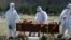 Cemetery workers wearing protective gear bury a coronavirus victim at a cemetery on the outskirts of St. Petersburg, Russia, on May 6.