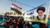 Supporters of the Al Sairun Party, which is backed by the Iraqi Shi'ite cleric Moqtada al-Sadr, hold a poster of Iraq's top Shi'ite cleric, Grand Ayatollah Ali al-Sistani, while attending a campaign rally, ahead of the parliamentary election in Baghdad, Iraq May 4, 2018. 