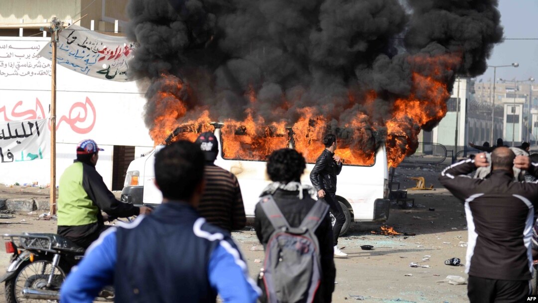 Smoke billows from a burning minibus belonging to a satellite channel after it was set on fire by Egyptian protesters outside the Port Said prison in the Egyptian canal city on January 26.