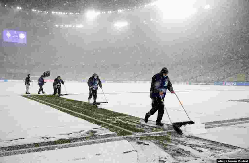 Ukrainian ground staff clear snow off the field before the Champions League soccer game between&nbsp;Dynamo Kyiv and Bayern Munich on November 23.&nbsp;